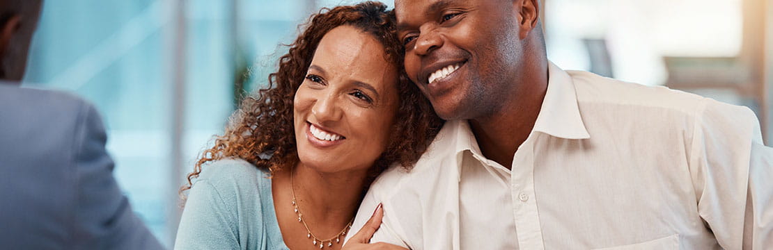 Happy couple came to a successful agreement with their insurance agent on a meeting in the office.